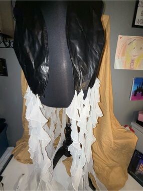 Women’s Ashley Stewart Black Faux Leather Vest with White Ruffle Trim hanging